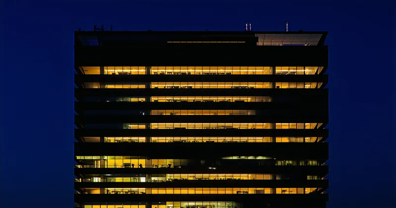 Office building with some vacant dark floors and some lit floors showing absorption