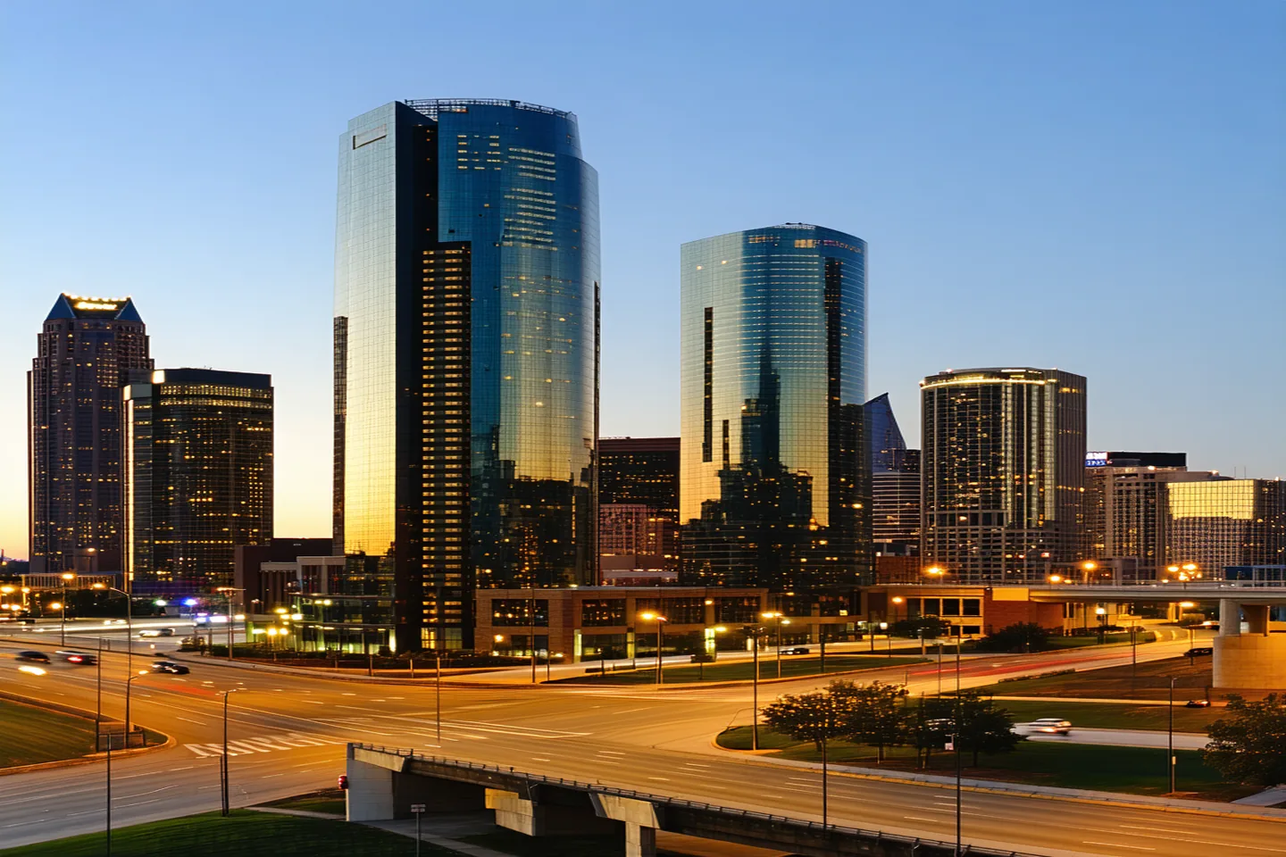 Dallas commercial district skyline at dusk with warm amber light on glass office towers